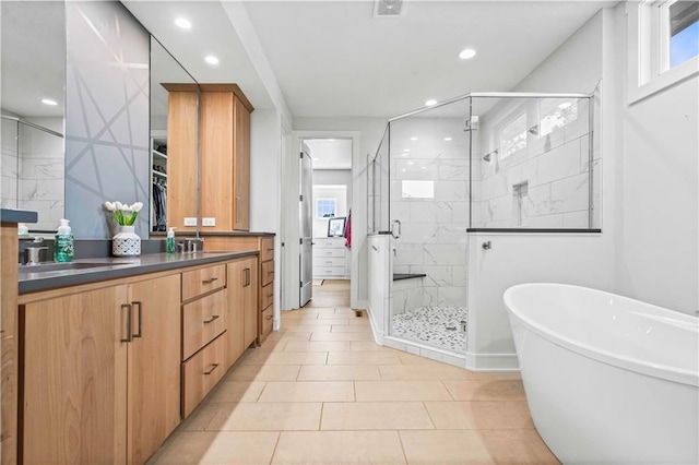 bathroom with tile patterned flooring, separate shower and tub, and vanity