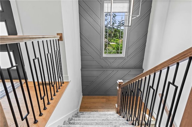 stairs featuring a notable chandelier and hardwood / wood-style floors