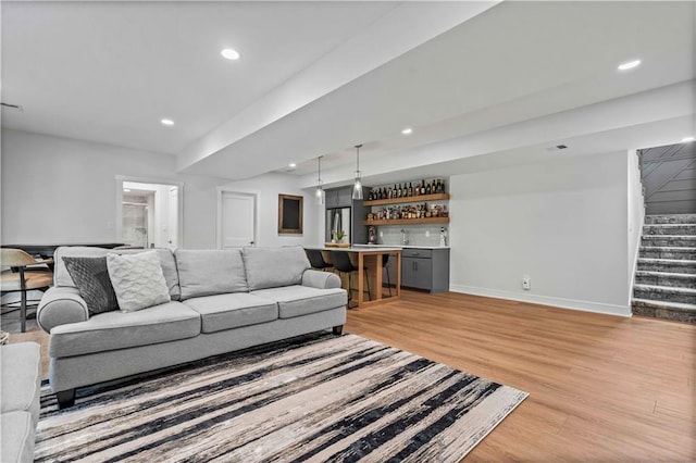 living room with light wood-type flooring and indoor bar