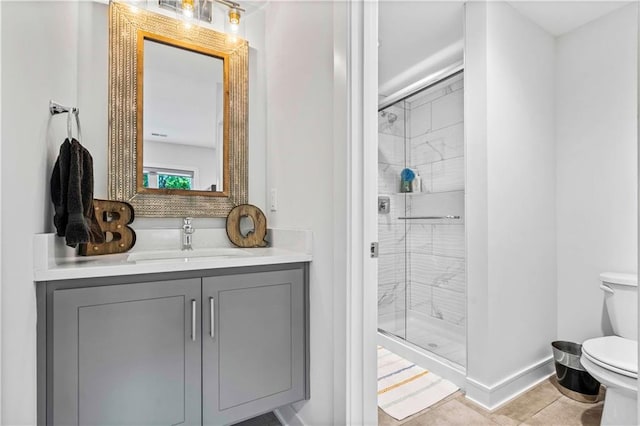 bathroom featuring vanity, tile patterned flooring, walk in shower, and toilet