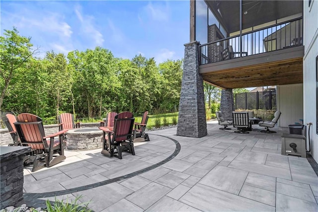 view of patio / terrace with an outdoor living space with a fire pit and a balcony