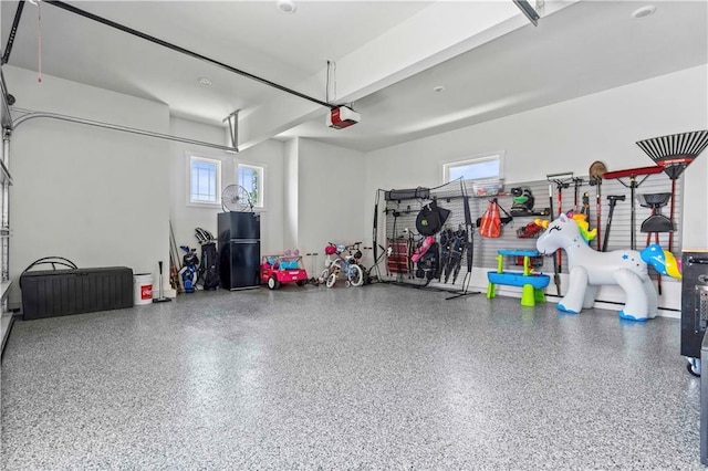 garage featuring a garage door opener and black refrigerator