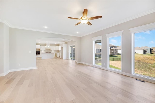 unfurnished living room featuring ceiling fan, ornamental molding, and light hardwood / wood-style floors