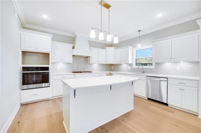 kitchen with custom exhaust hood, a kitchen island, stainless steel appliances, and white cabinetry