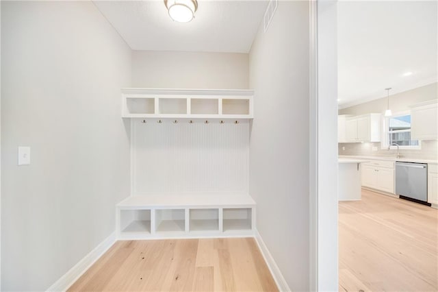 mudroom with sink and light hardwood / wood-style floors