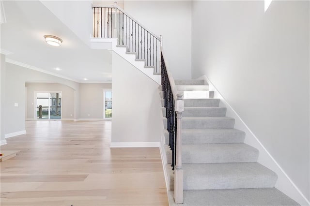 stairway with hardwood / wood-style flooring and ornamental molding