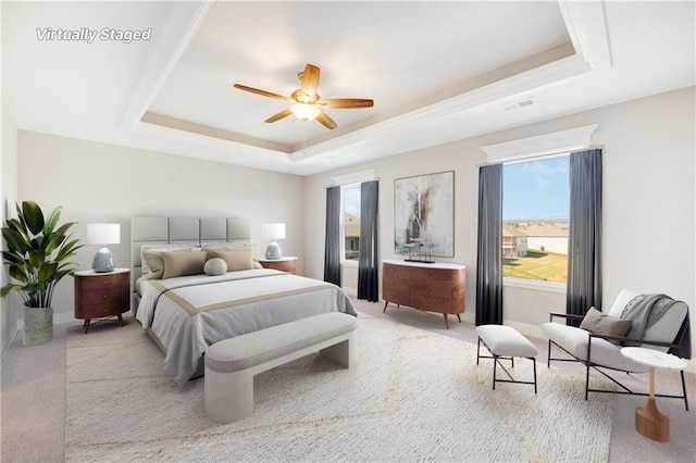 bedroom featuring ceiling fan, a raised ceiling, and light colored carpet