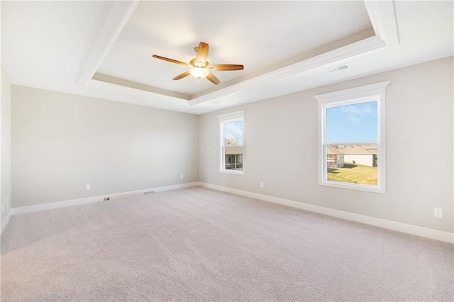 carpeted empty room with a tray ceiling and ceiling fan