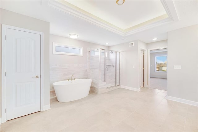 bathroom with tile walls, plus walk in shower, and a raised ceiling