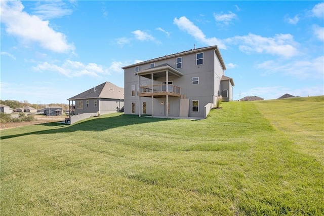 rear view of property featuring a balcony and a lawn