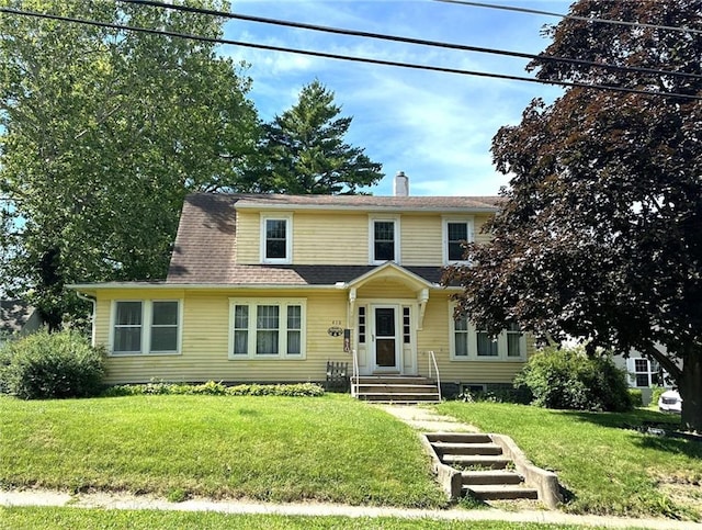 view of front of house featuring a chimney and a front lawn