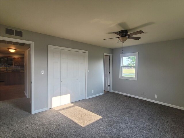 501 Meadow Ln, Fort Scott, KS 66701 - unfurnished bedroom with ceiling fan, dark carpet, and a closet