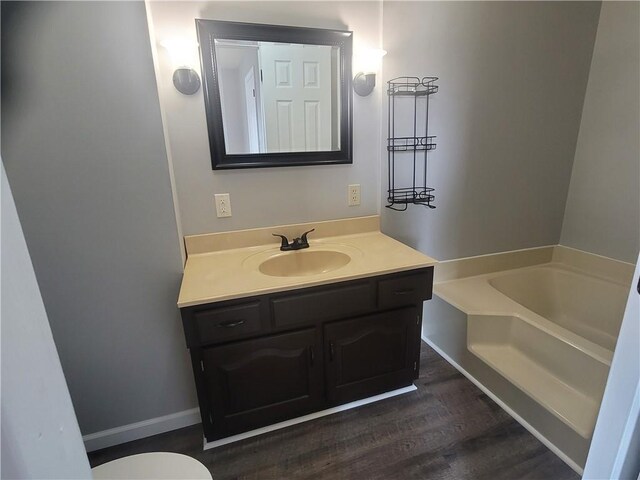 501 Meadow Ln, Fort Scott, KS 66701 - bathroom with vanity, hardwood / wood-style floors, and a tub to relax in