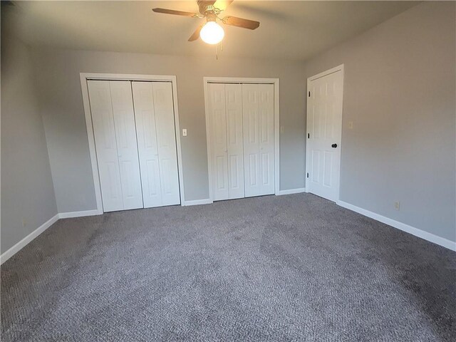 501 Meadow Ln, Fort Scott, KS 66701 - unfurnished bedroom with two closets, ceiling fan, and dark colored carpet