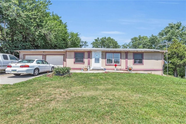 ranch-style house with a garage and a front lawn