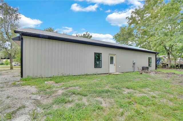 rear view of house featuring a lawn and cooling unit