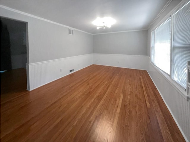 spare room featuring hardwood / wood-style flooring and crown molding