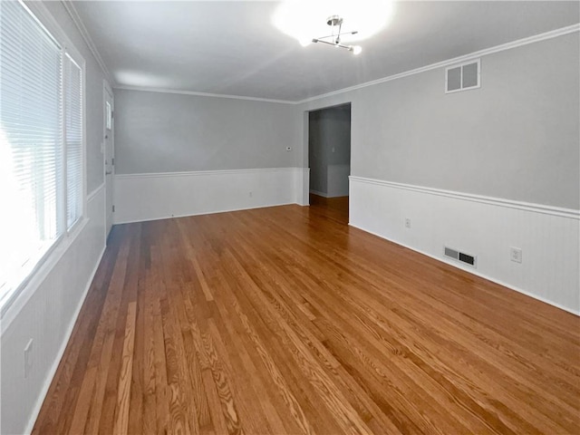 empty room with hardwood / wood-style floors and ornamental molding