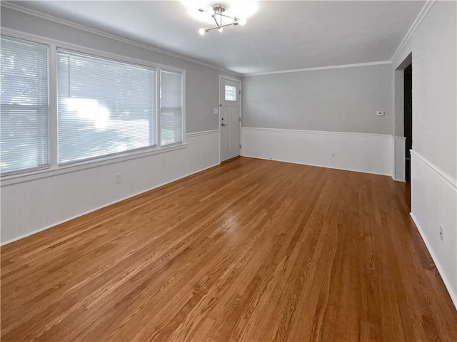 empty room with ornamental molding and hardwood / wood-style flooring