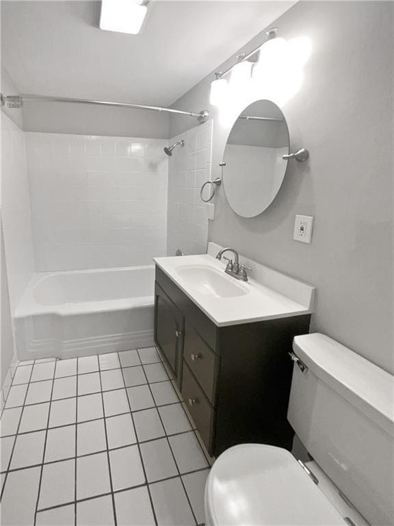 full bathroom with tile patterned floors, vanity, tiled shower / bath combo, and toilet