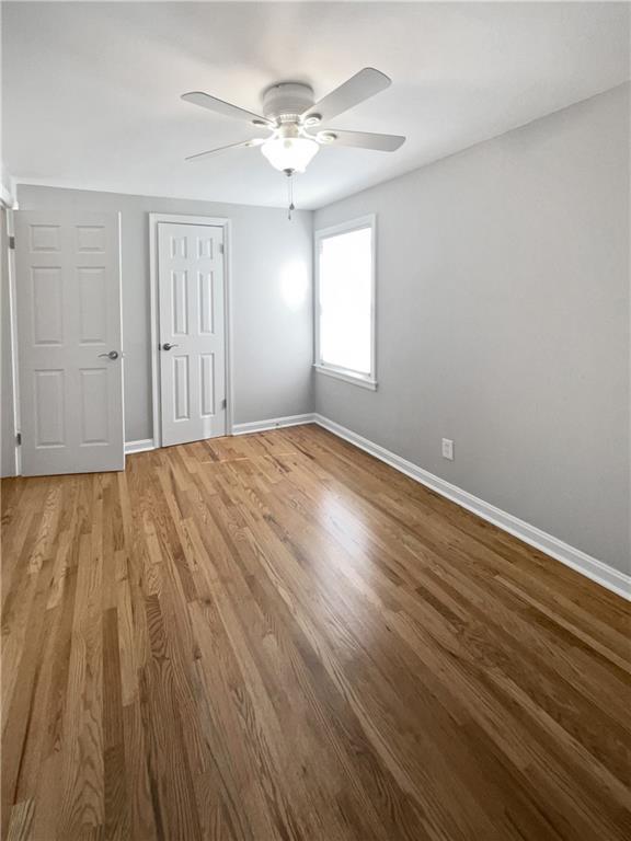 empty room featuring ceiling fan and hardwood / wood-style floors