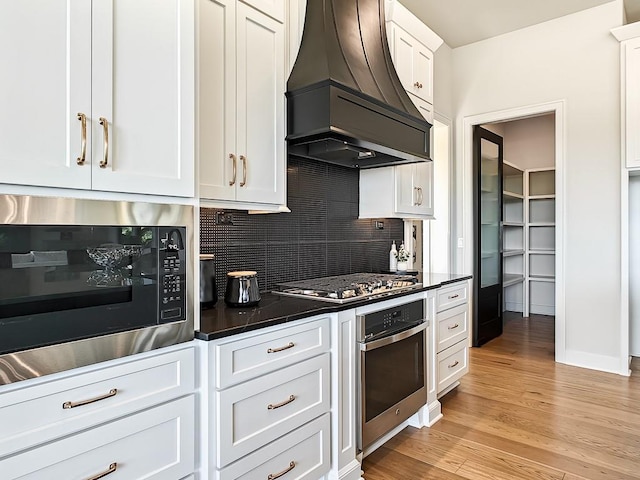 8013 Millridge St, Shawnee, KS 66220 - kitchen featuring dark countertops, decorative backsplash, stainless steel appliances, and custom exhaust hood