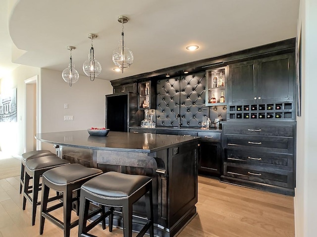8013 Millridge St, Shawnee, KS 66220 - bar with a sink, high end black refrigerator, light wood-type flooring, decorative light fixtures, and wet bar