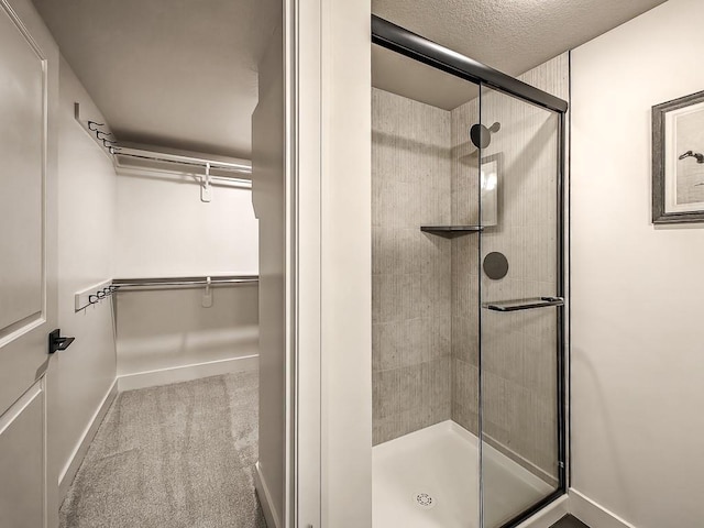 8013 Millridge St, Shawnee, KS 66220 - full bath with a walk in closet, a textured ceiling, baseboards, and a stall shower