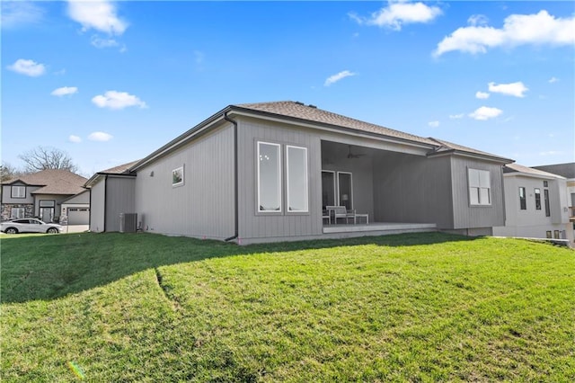 back of property featuring central AC and a yard