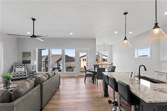 living room featuring a wealth of natural light, sink, hardwood / wood-style flooring, and ceiling fan