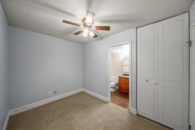 unfurnished bedroom with ceiling fan, connected bathroom, light colored carpet, and a closet