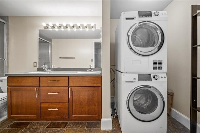 laundry room with stacked washer / drying machine and sink