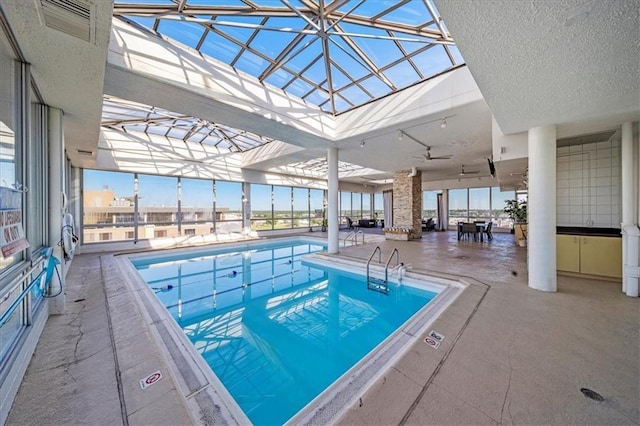 view of swimming pool featuring glass enclosure