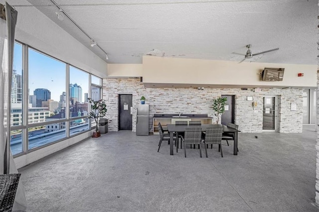 dining room featuring ceiling fan, concrete floors, and a textured ceiling