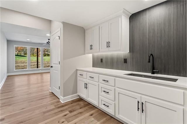 washroom with light wood-type flooring, ceiling fan, and sink