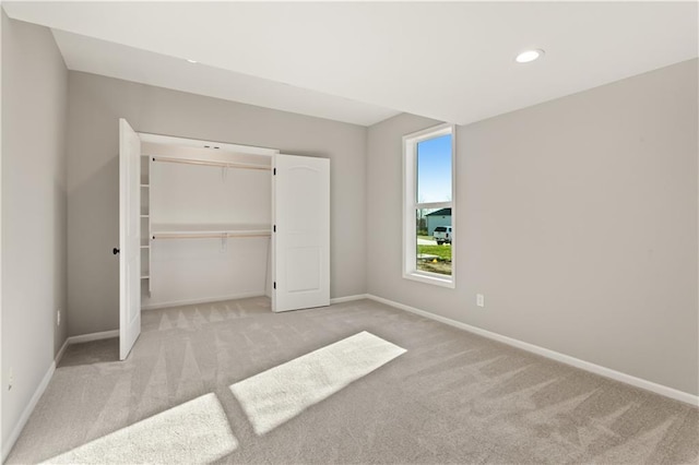 unfurnished bedroom featuring light colored carpet and a closet