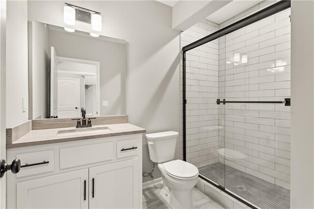 bathroom featuring vanity, an enclosed shower, and toilet