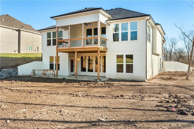 back of property with ceiling fan, a balcony, and a patio