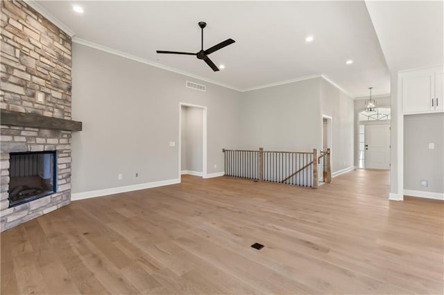 unfurnished living room featuring crown molding, a fireplace, and light hardwood / wood-style floors