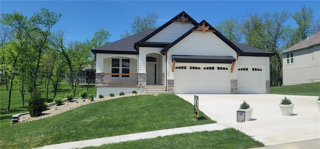 craftsman house with a garage, a front yard, driveway, and stone siding