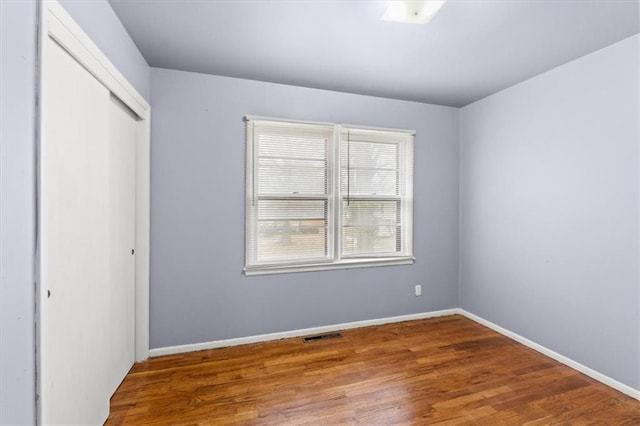 unfurnished bedroom with hardwood / wood-style flooring and a closet