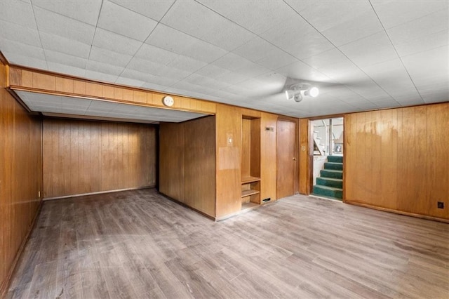 interior space with hardwood / wood-style floors and wooden walls