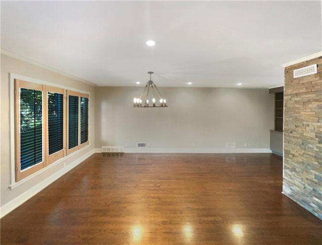 unfurnished room with ornamental molding, dark wood-type flooring, and a notable chandelier