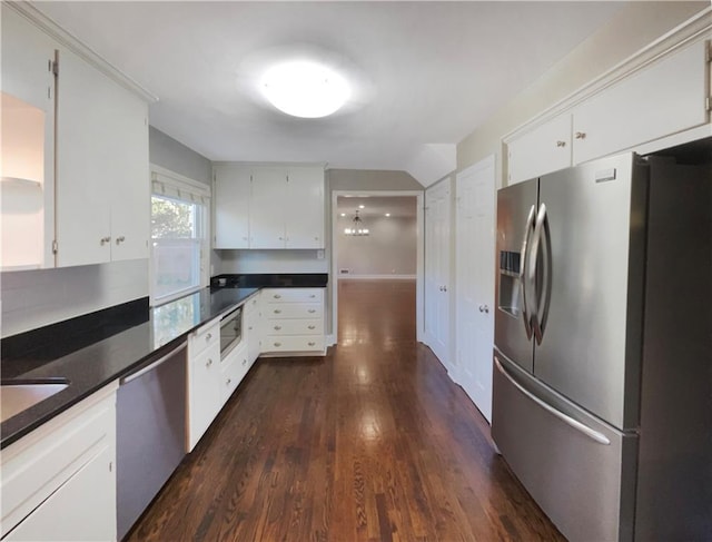 kitchen featuring white cabinets, dark hardwood / wood-style floors, appliances with stainless steel finishes, and tasteful backsplash