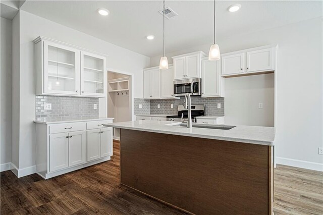 27017 E Olive Dr, Lees Summit, MO 64086 - kitchen with stainless steel appliances, dark wood finished floors, white cabinetry, decorative backsplash, and recessed lighting