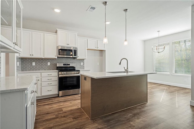 kitchen with a kitchen island with sink, dark wood-type flooring, sink, appliances with stainless steel finishes, and white cabinetry