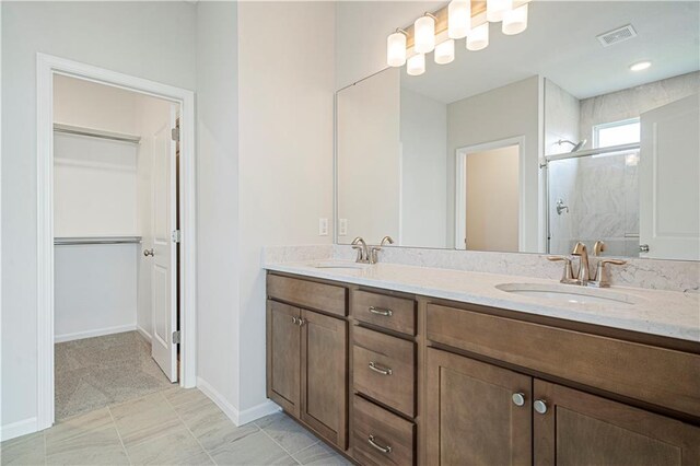 27017 E Olive Dr, Lees Summit, MO 64086 - bathroom featuring a stall shower, double vanity, a walk in closet, and baseboards
