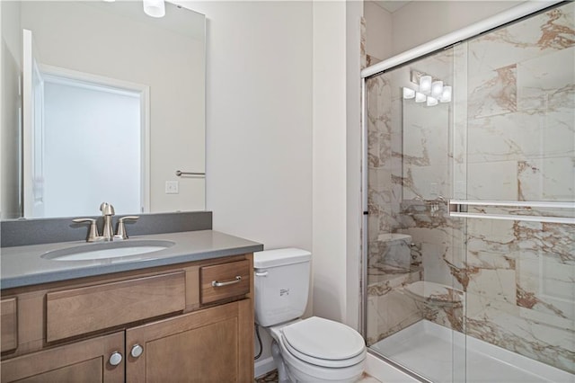 bathroom with vanity, a shower with shower door, and toilet