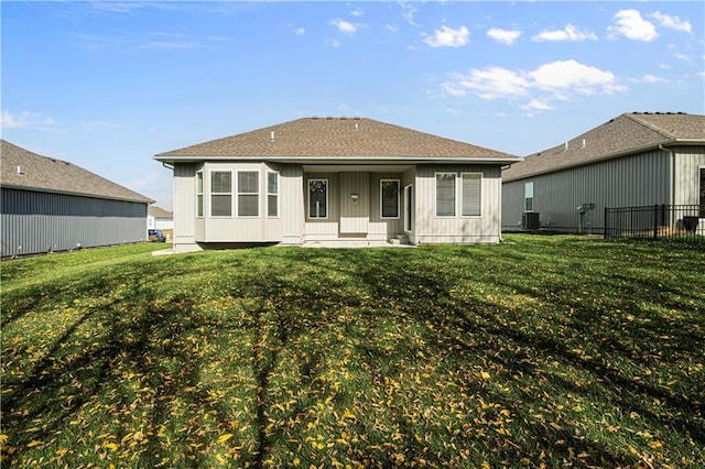 rear view of house with a lawn and central AC unit