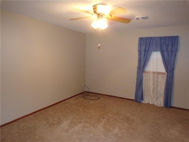 unfurnished room with a textured ceiling, ceiling fan, and carpet flooring